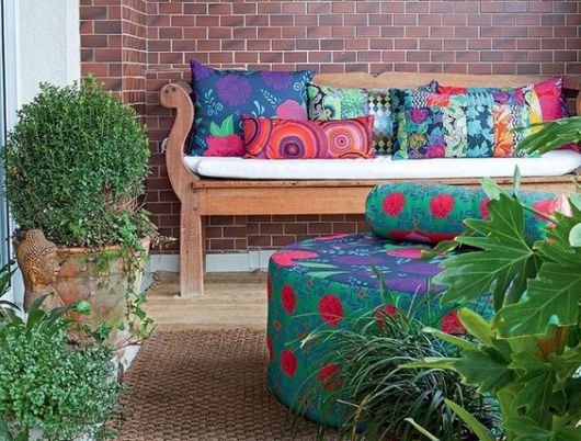 sofá de madeira com almofadas coloridas