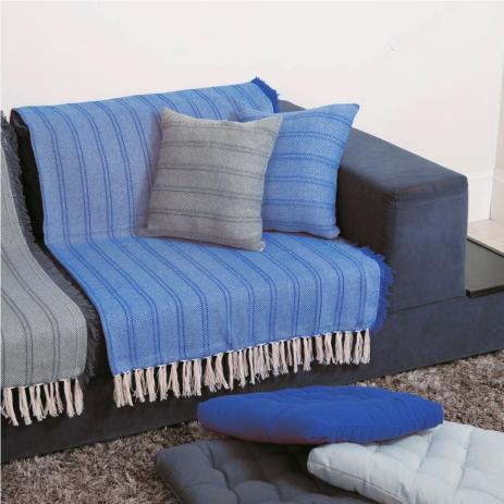 Manta azul claro colocada em sofá azul escuro.