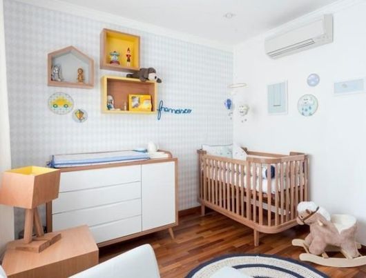 Berço de madeira em quarto infantil com cores claras.