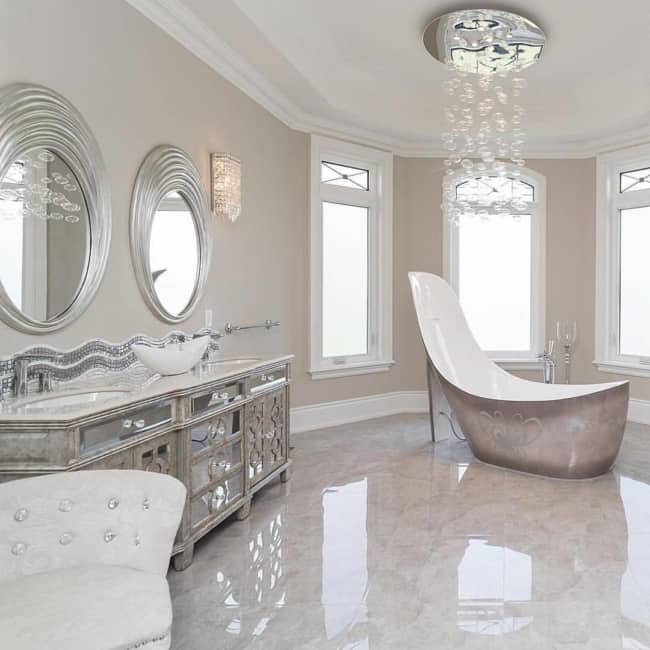 Banheiro clássico luxuoso com lustre de cristais pendente e banheira extravagante
