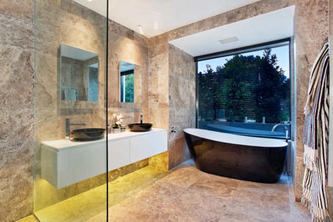 Banheiro com banheira e piso de mármore travertino