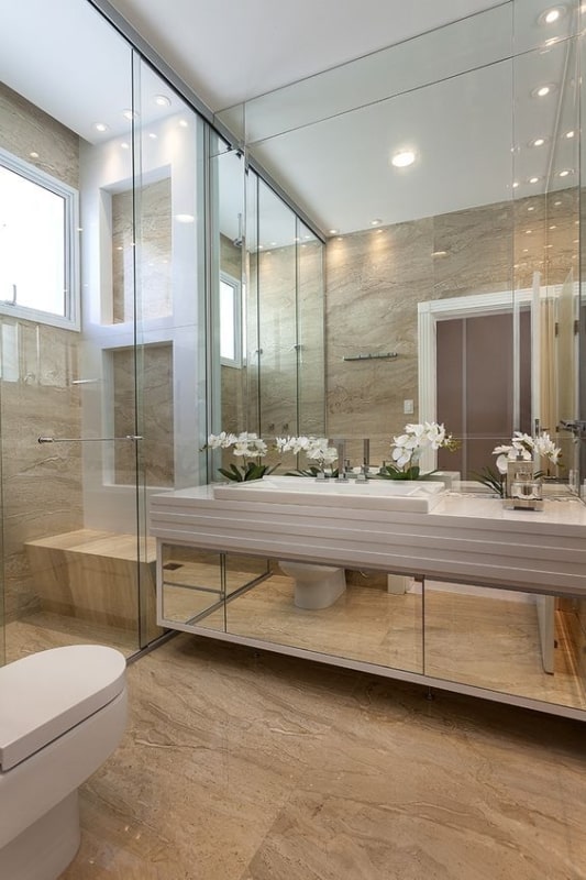 Banheiro com piso de mármore travertino e armário espelhado 1