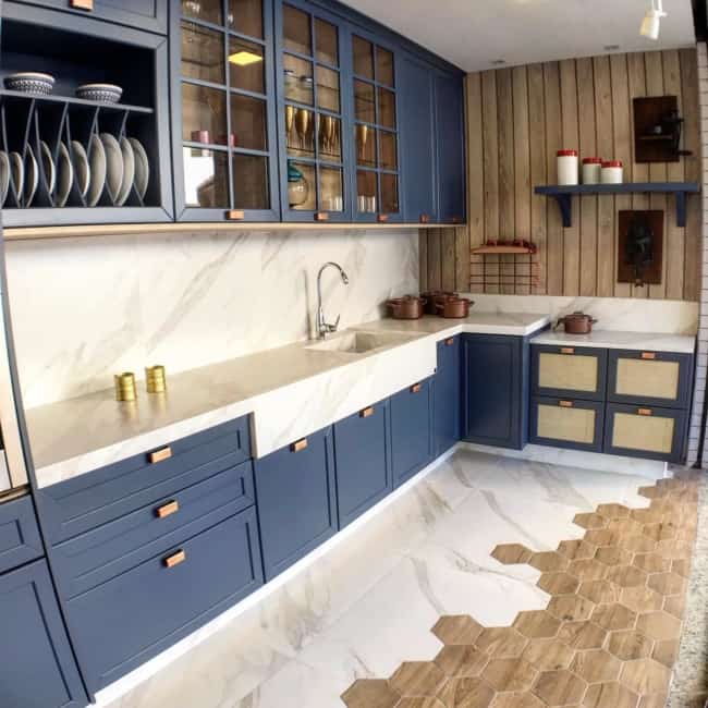 Bancada marmorizada branca e armários azuis na cozinha