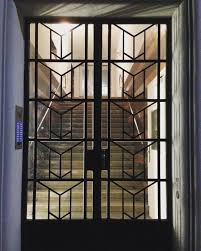 Porta de ferro com formas geométricas e placas de vidro