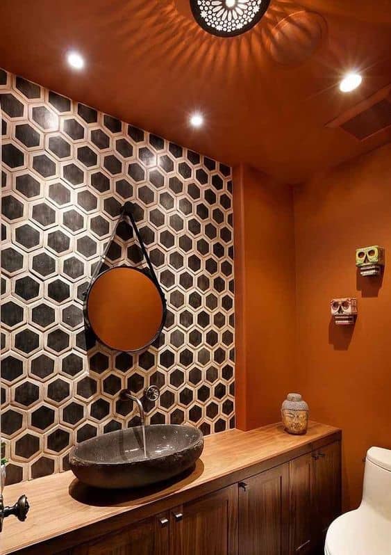 Banheiro estiloso com estampa geométrica e parede cor laranja