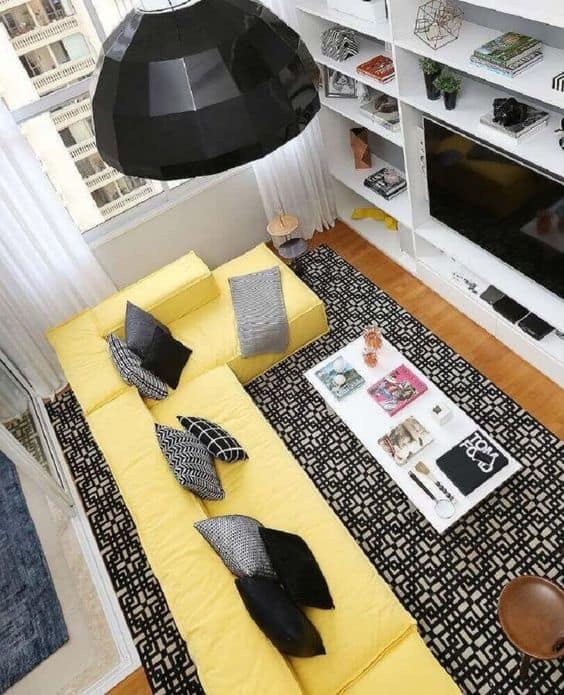 sala com sofá amarelo e tapete preto