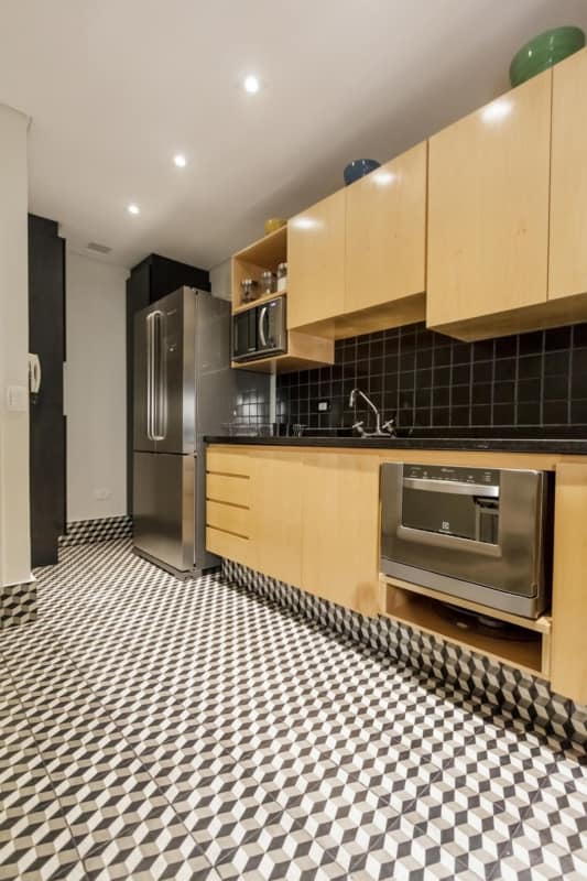 Cozinha com piso preto e branco e armários amarelos