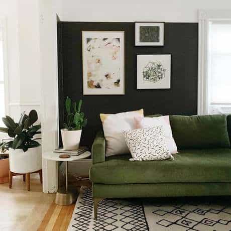 sala com parede preta e sofá verde