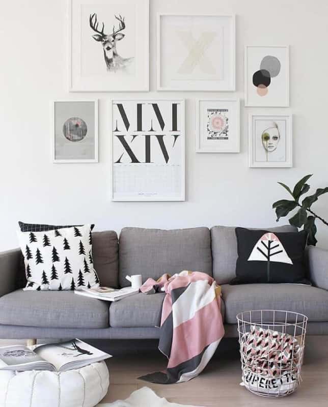 sala com sofá cinza e parede de quadros