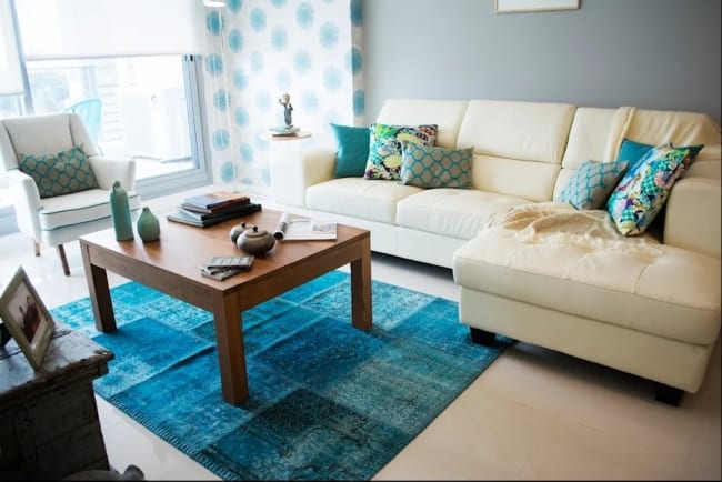 sala com sofá cor creme e tapete azul