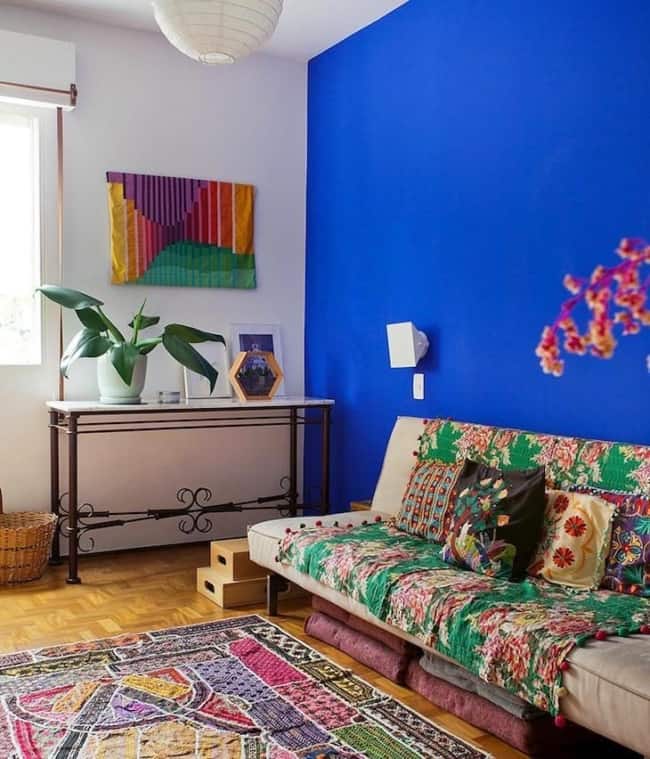 sala simples com parede azul royal e decoração colorida