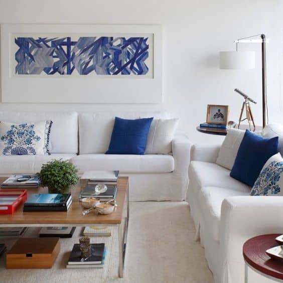 sala com sofás brancos e almofadas azul
