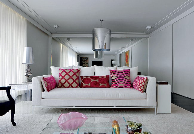 sala com sofá branco e almofadas vermelhas