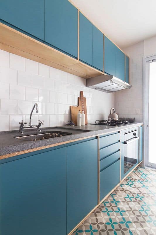 cozinha com azulejos brancos e armários azul