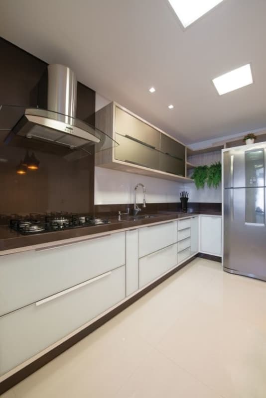 cozinha moderna com armários brancos e bancada marrom