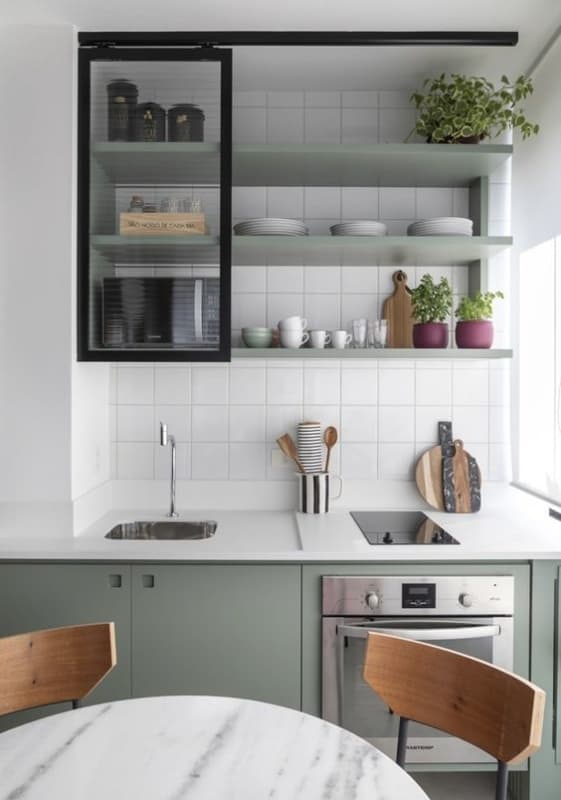 cozinha pequena com bancada branca e armários em verde claro
