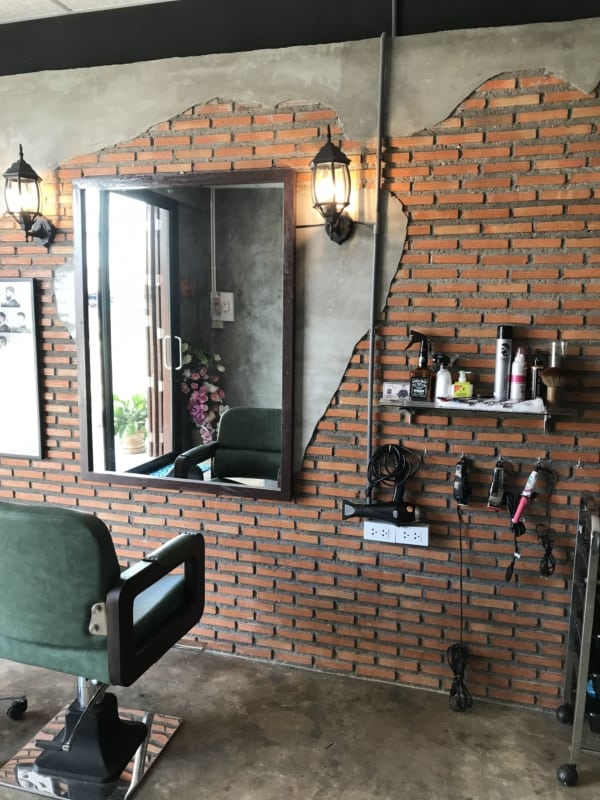 decoração para barbearia com parede de tijolos aparentes