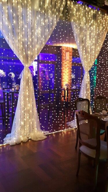 decoração de festa com cortina de luzinhas e cortina de tecido