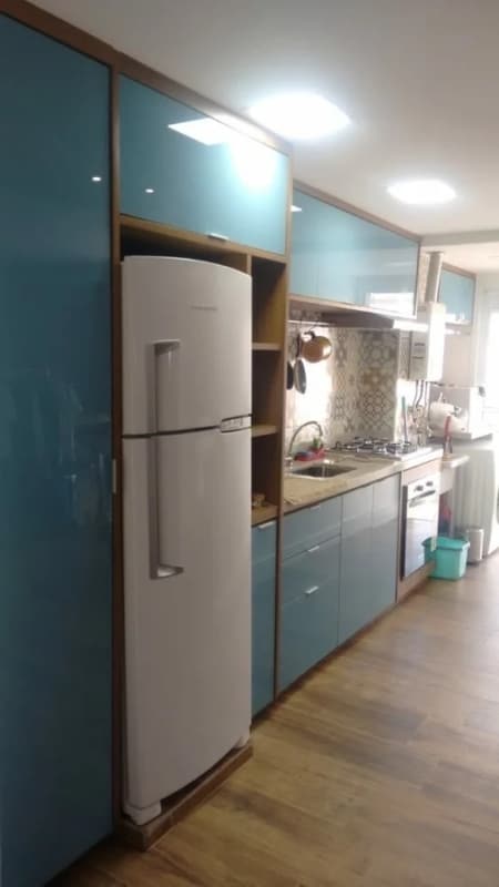 cozinha com armários em compensado naval e acabamento em vidro azul