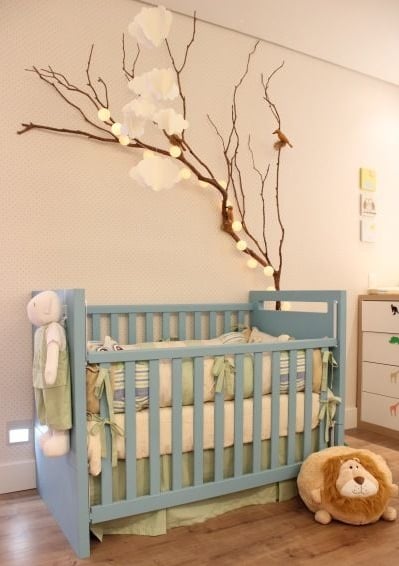 galhos secos com luzinhas decorando quarto de bebe