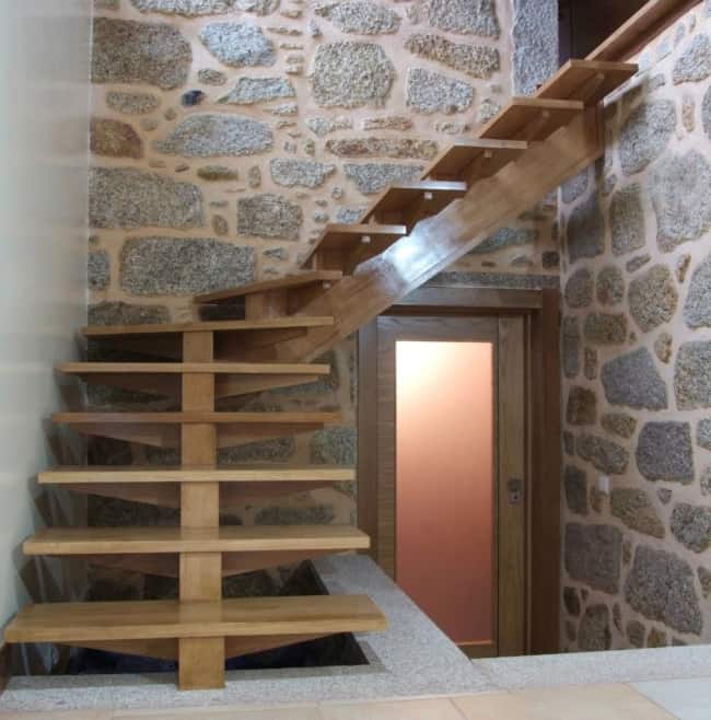 escada em L de madeira clara com degraus vazados