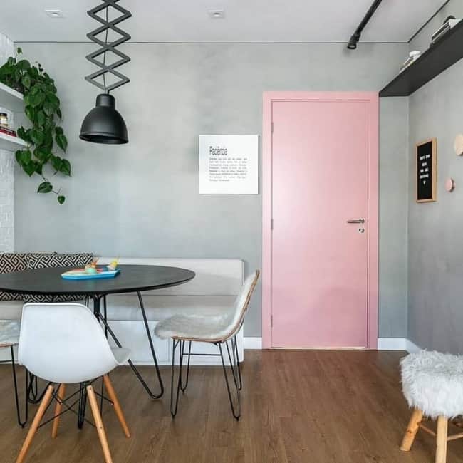 sala com parede cinza e porta rosa