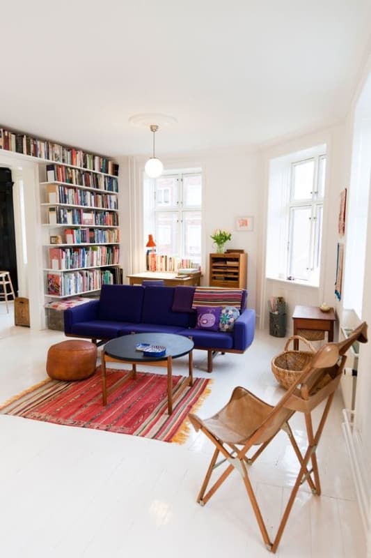 sala com piso branco e sofa violeta