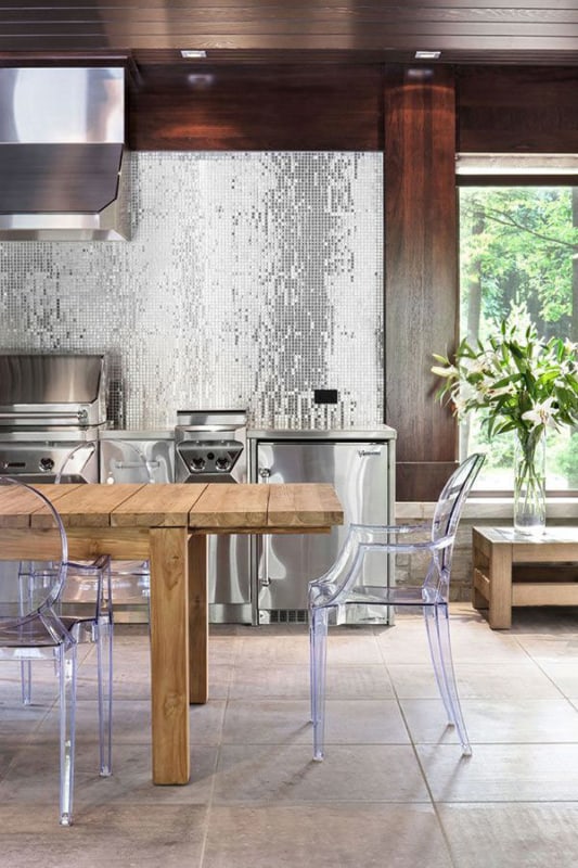 cozinha com mesa de madeira e cadeiras transparentes