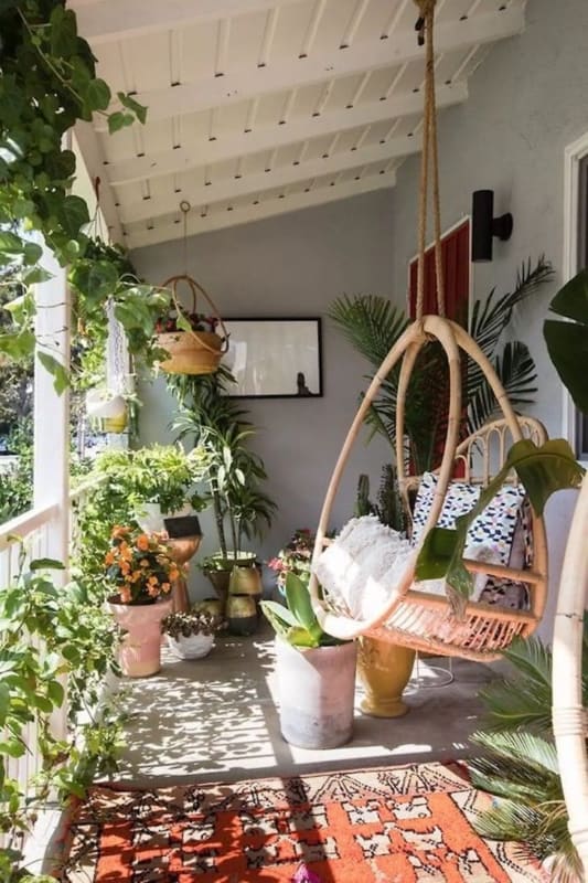 varanda decorada com plantas e cadeira suspensa