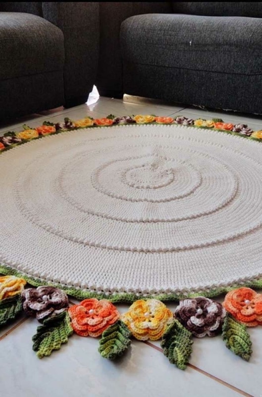 1 tapete redondo de croche com flores na sala