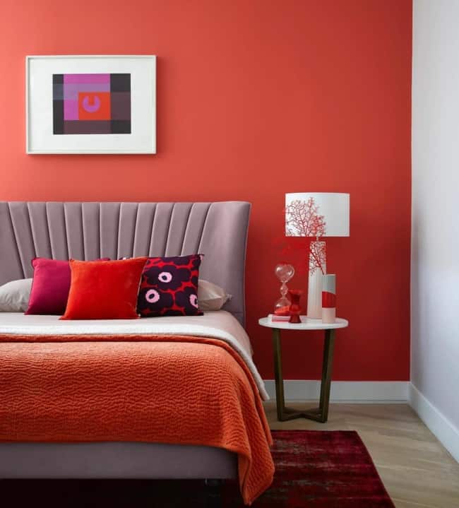 11 quarto decorado com parede vermelha e cama cinza